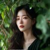 内容顾问苏暮的照片，知性气质，轻微侧脸，背景有绿植，温暖自然